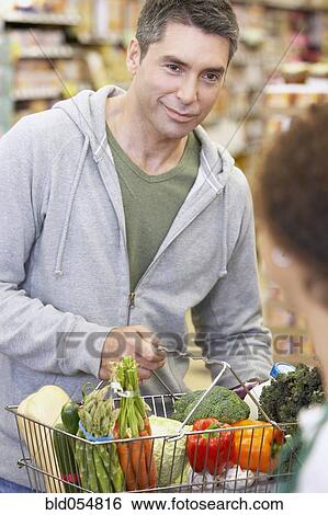 Hispanic man checking out at grocery store View Large Photo Image Stock Photograph - Hispanic man checking out at grocery store. Fotosearch