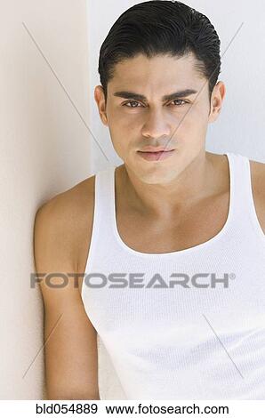Stock Photo - Hispanic man leaning on wall. Fotosearch