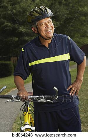 Hispanic man next to bicycle View Large Photo Image Stock Image - Hispanic man next to bicycle. Fotosearch