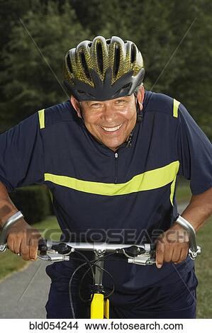 Picture - Hispanic man riding bicycle. Fotosearch