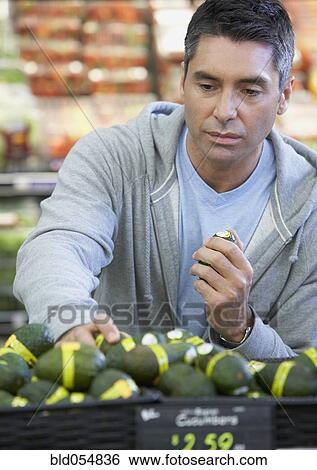 Stock Photograph - Hispanic man shopping for produce. Fotosearch