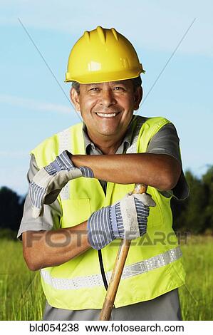 Hispanic man wearing hard hat and reflective vest View Large Photo Image Stock Photo - Hispanic man wearing hard hat and reflective vest. Fotosearch