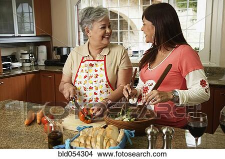 Hispanic mother and adult daughter preparing food View Large Photo Image Picture - Hispanic mother and adult daughter preparing food. Fotosearch