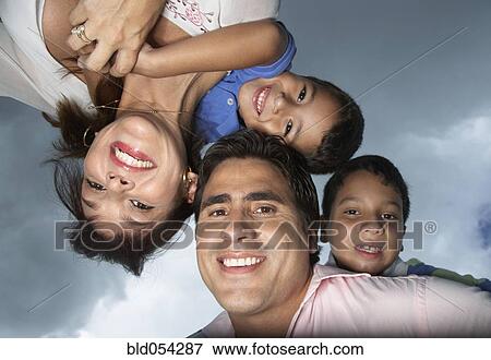 Stock Photo - Hispanic parents giving children piggy back rides. Fotosearch