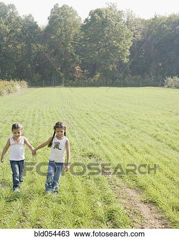 Hispanic sisters holding hands in field View Large Photo Image Stock Image - Hispanic sisters holding hands in field. Fotosearch