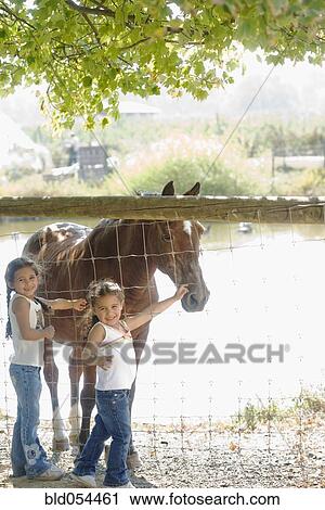Hispanic sisters petting horse View Large Photo Image Stock Image - Hispanic sisters petting horse. Fotosearch