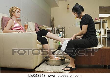 Stock Photo - Hispanic woman receiving spa pedicure. Fotosearch