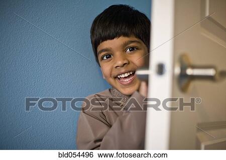 Indian boy laughing behind door View Large Photo Image Stock Photograph - Indian boy laughing behind door. Fotosearch