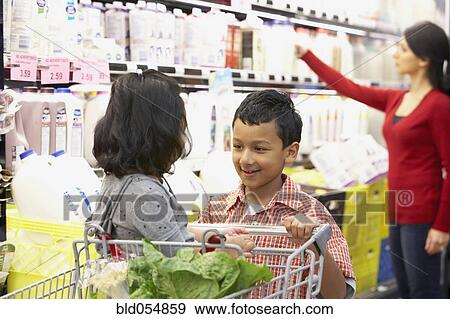 Stock Photo - Indian brother pushing sister in shopping cart. Fotosearch