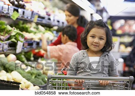 Stock Photo - Indian girl sitting in shopping cart. Fotosearch