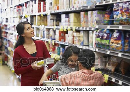 Stock Photo - Indian mother shopping in grocery store. Fotosearch