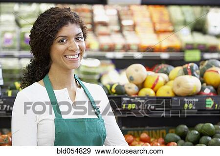 Stock Photo - Mixed Race clerk in grocery store. Fotosearch
