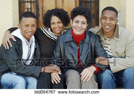 Stock Photo - Mixed Race mother and adult children on porch steps. Fotosearch