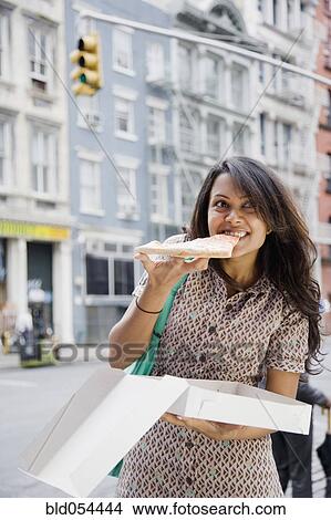 Mixed Race woman eating pizza View Large Photo Image Picture - Mixed Race woman eating pizza. Fotosearch