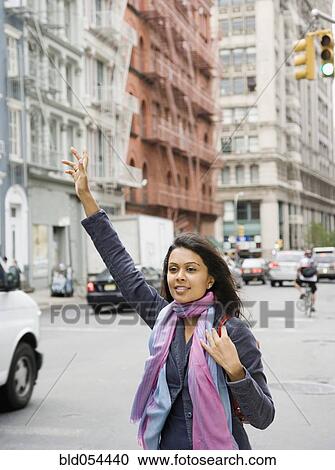 Mixed Race woman hailing taxi cab View Large Photo Image Stock Image - Mixed Race woman hailing taxi cab. Fotosearch