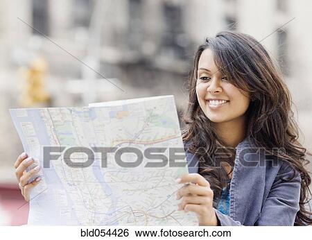 Stock Photograph - Mixed Race woman looking at map. Fotosearch
