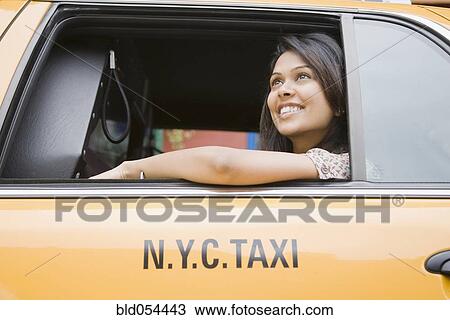Stock Image - Mixed Race woman looking out taxi cab window. Fotosearch