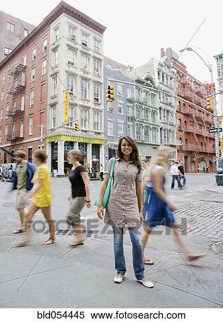 Stock Photography - Mixed Race woman standing on urban sidewalk. Fotosearch