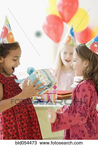 Stock Image - Multi-ethnic girls at birthday party. Fotosearch