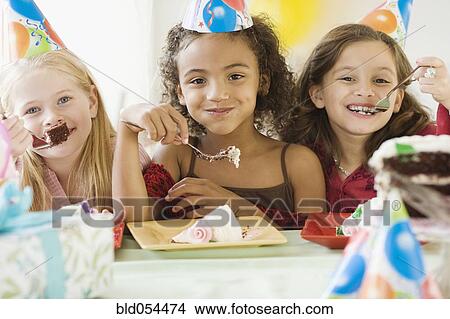 Picture - Multi-ethnic girls eating birthday cake. Fotosearch