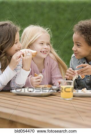Stock Image - Multi-ethnic girls eating sandwiches. Fotosearch