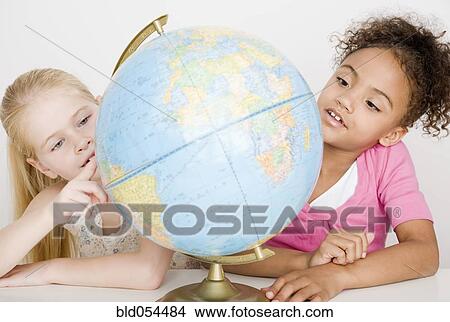 Multi-ethnic girls looking at globe View Large Photo Image Picture - Multi-ethnic girls looking at globe. Fotosearch