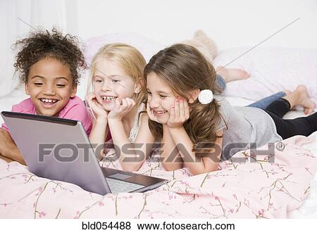 Multi-ethnic girls looking at laptop View Large Photo Image Stock Photo - Multi-ethnic girls looking at laptop. Fotosearch