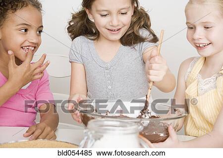 Multi-ethnic girls making batter View Large Photo Image Stock Photography - Multi-ethnic girls making batter. Fotosearch