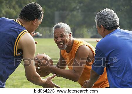 Stock Image - Multi-ethnic men playing basketball. Fotosearch