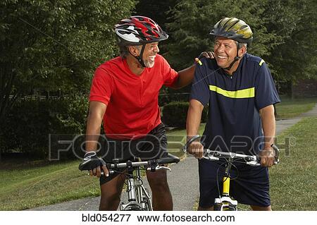 Stock Photo - Multi-ethnic men riding bicycles. Fotosearch