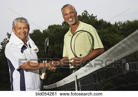 Multi-ethnic men shaking hands on tennis court View Large Photo Image Stock Image - Multi-ethnic men shaking hands on tennis court. Fotosearch