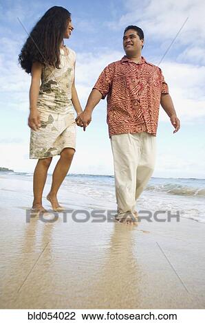 Pacific Islander couple walking on beach View Large Photo Image Stock Image - Pacific Islander couple walking on beach. Fotosearch
