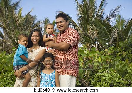 Stock Photo - Pacific Islander family in front of palm trees. Fotosearch
