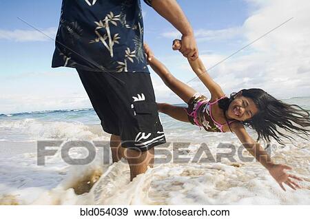 Pacific Islander father and daughter playing at beach View Large Photo Image Stock Photo - Pacific Islander father and daughter playing at beach. Fotosearch