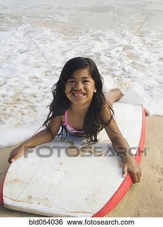 Pacific Islander girl laying on boogie board View Large Photo Image Stock Photograph - Pacific Islander girl laying on boogie board. Fotosearch