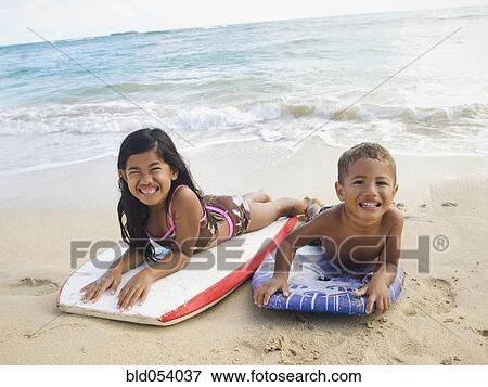 Pacific Islander siblings laying on boogie boards View Large Photo Image Stock Photo - Pacific Islander siblings laying on boogie boards. Fotosearch