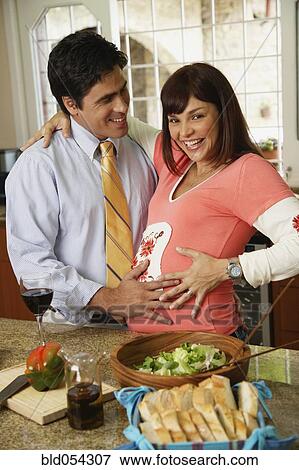 Pregnant Hispanic couple hugging View Large Photo Image Stock Photo - Pregnant Hispanic couple hugging. Fotosearch