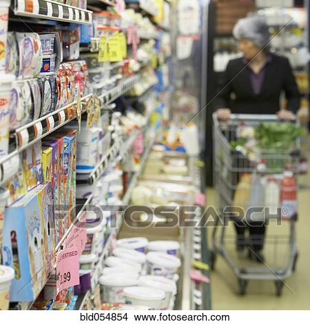 Picture - Senior Asian woman shopping in grocery store. Fotosearch