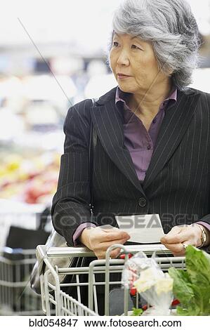 Senior Asian woman shopping in grocery store View Large Photo Image Stock Photo - Senior Asian woman shopping in grocery store. Fotosearch