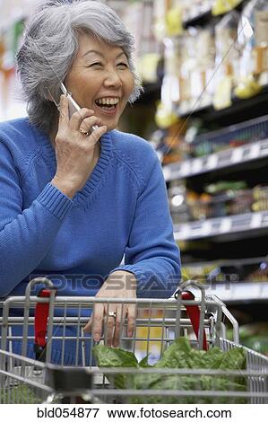 Stock Photo - Senior Asian woman talking on cell phone. Fotosearch