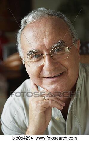 Picture - Senior Hispanic man leaning chin on hand. Fotosearch
