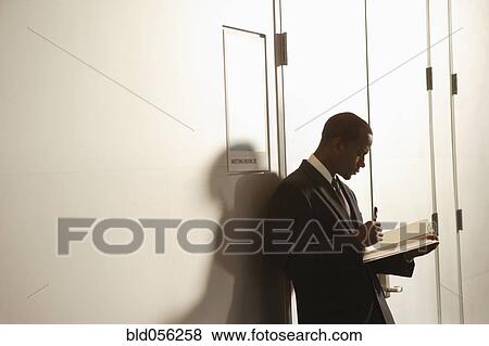 Stock Photo - African American businessman looking at paperwork. Fotosearch
