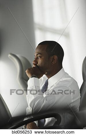 Stock Image - African American businessman sitting in chair. Fotosearch