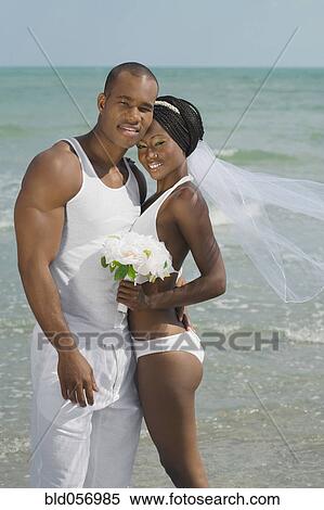 African bride and groom hugging at beach View Large Photo Image Stock Photography - African bride and groom hugging at beach. Fotosearch