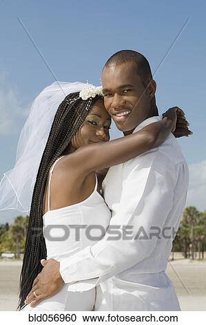 Stock Image - African bride and groom hugging. Fotosearch