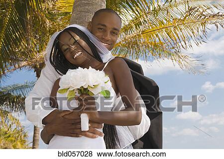Stock Photo - African bride and groom hugging. Fotosearch