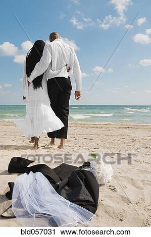 African bride and groom walking on beach View Large Photo Image Stock Image - African bride and groom walking on beach. Fotosearch