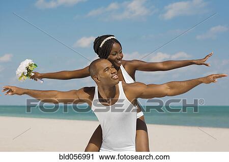 African bride and groom with arms outstretched at beach View Large Photo Image Stock Image - African bride and groom with arms outstretched at beach. Fotosearch