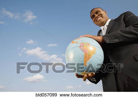 Stock Photo - African businessman holding globe. Fotosearch
