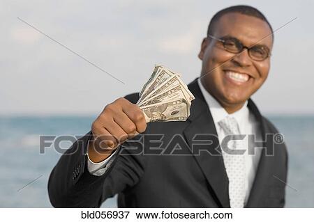 Stock Photo - African businessman holding money. Fotosearch